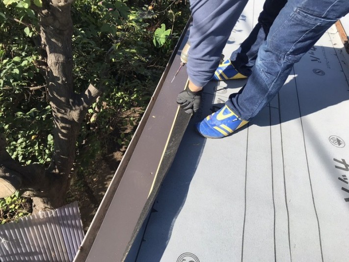 防水シートをめくっているところと唐草板金