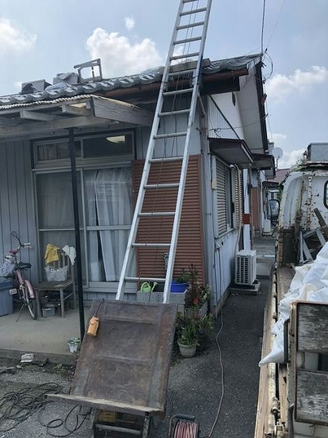 瓦屋根の工事中のトラックと脚立