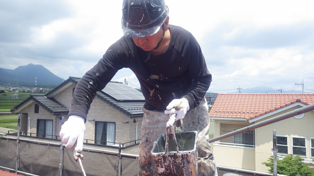 屋根を塗装する職人