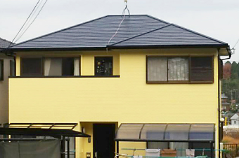 グレー色の屋根にイエローの外壁の一軒家